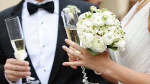 Hochzeitspaar mit Blumen und Sektgläsern Hochzeits DJ